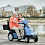 Afiscooter S4 shown in Blue Dual Seating With Couple Riding. Afiscooter S4 shown in Blue Dual Seating With Couple Riding.
